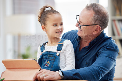 Buy stock photo Shot of a little girl and her grandfather using a digital tablet at home