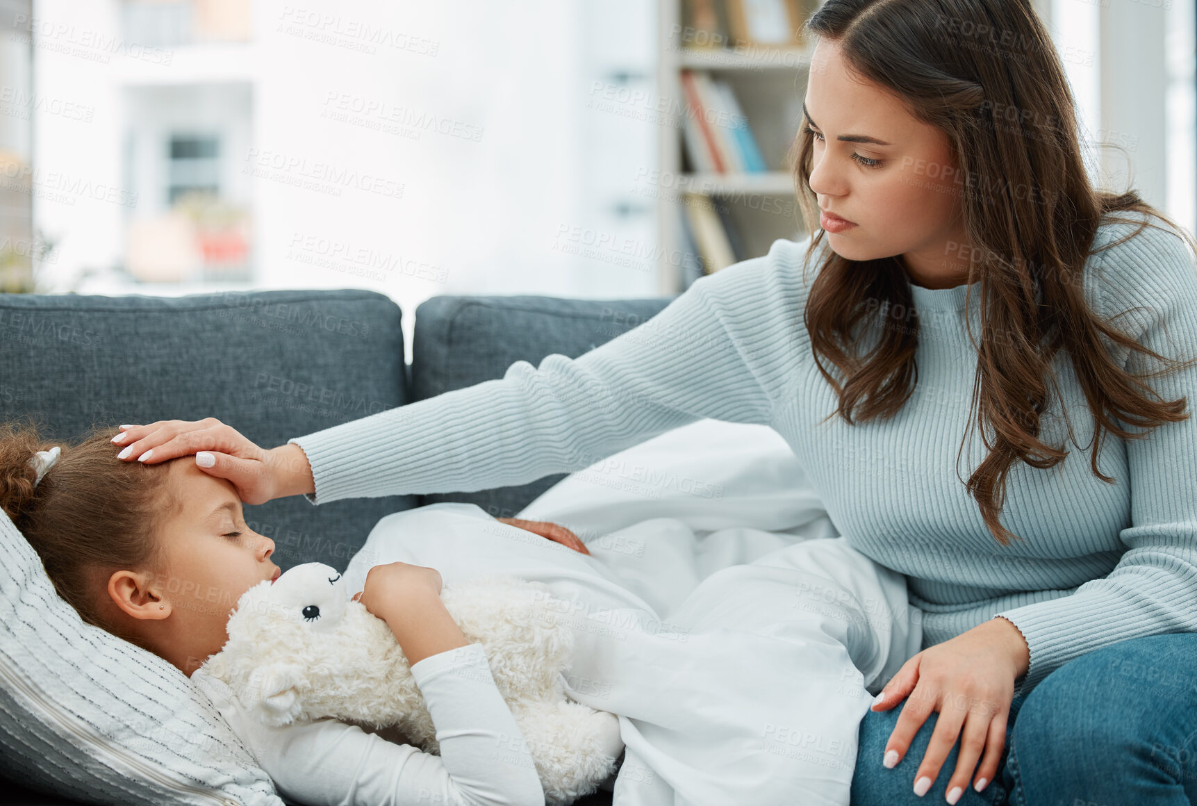 Buy stock photo Sick kid, mother and check temperature in home for virus, fever or mpox in living room. Mom, child and touch forehead for disease, allergy and help girl with stuffed animal for support or healthcare