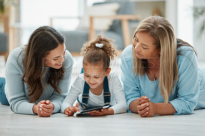 Buy stock photo Shot of a family spending time together while a little girl uses her digital tablet