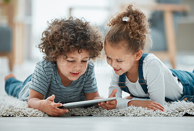 Buy stock photo Shot of two siblings playing together with their digital tablet