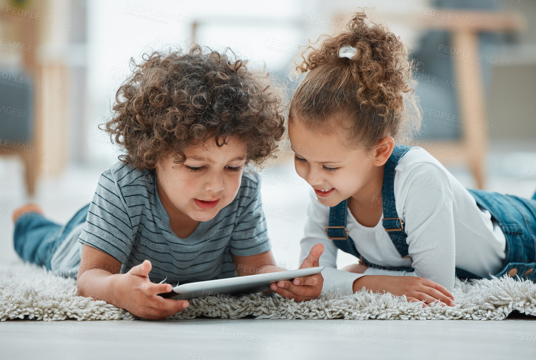 Buy stock photo Home, smile and children with tablet for connection, streaming cartoon and comedy movie with laugh. Siblings, boy and girl with digital for entertainment, funny video and bonding on carpet in house