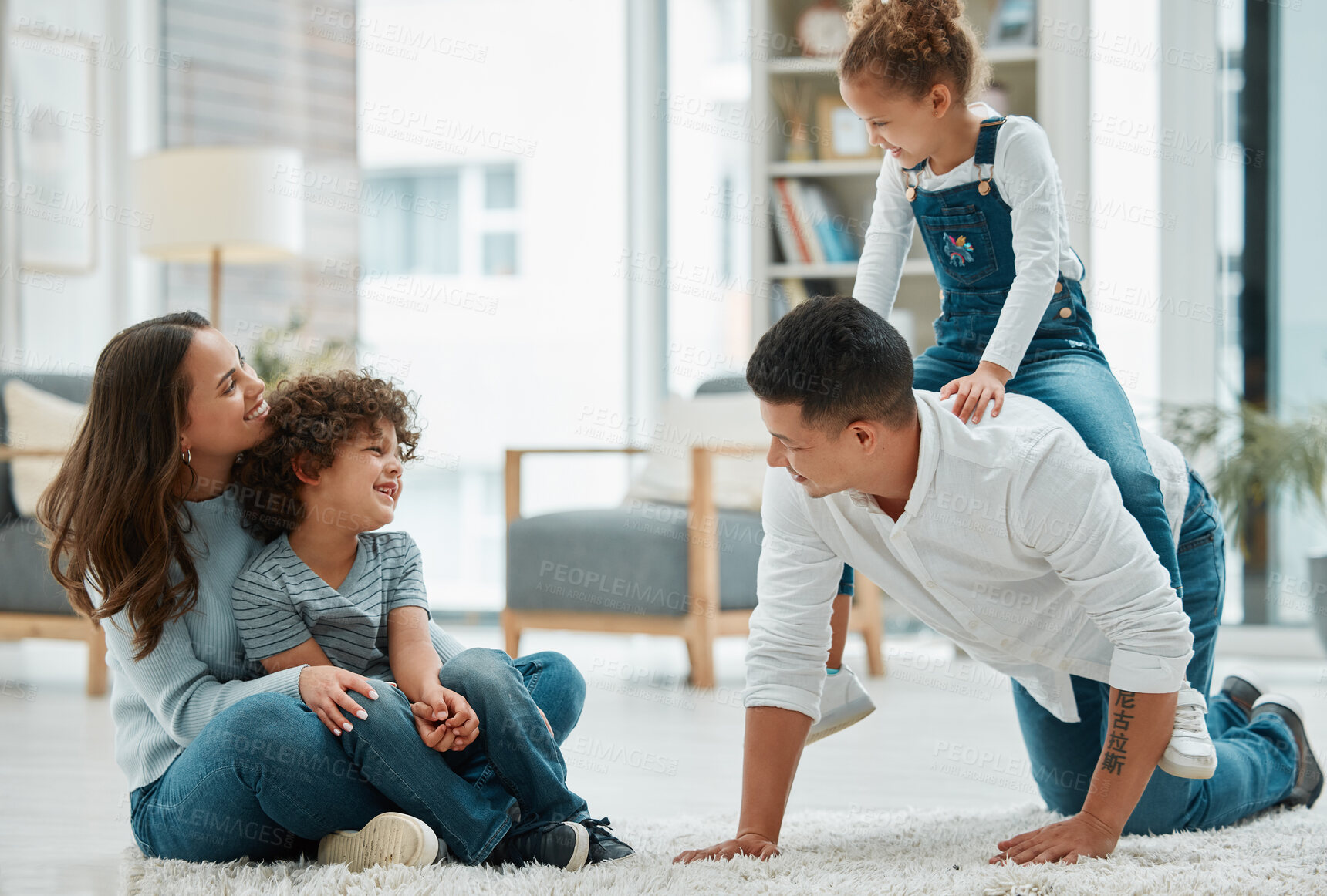 Buy stock photo Shot of a young family playing together at home