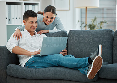 Buy stock photo Shot of a young couple spending time together using their laptop