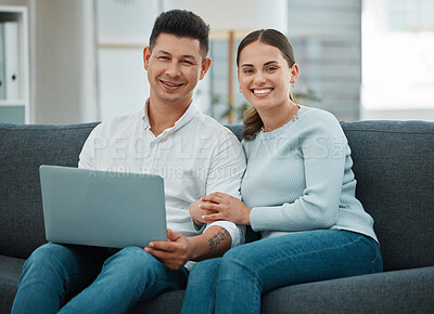 Buy stock photo Shot of a young couple spending time together using their laptop