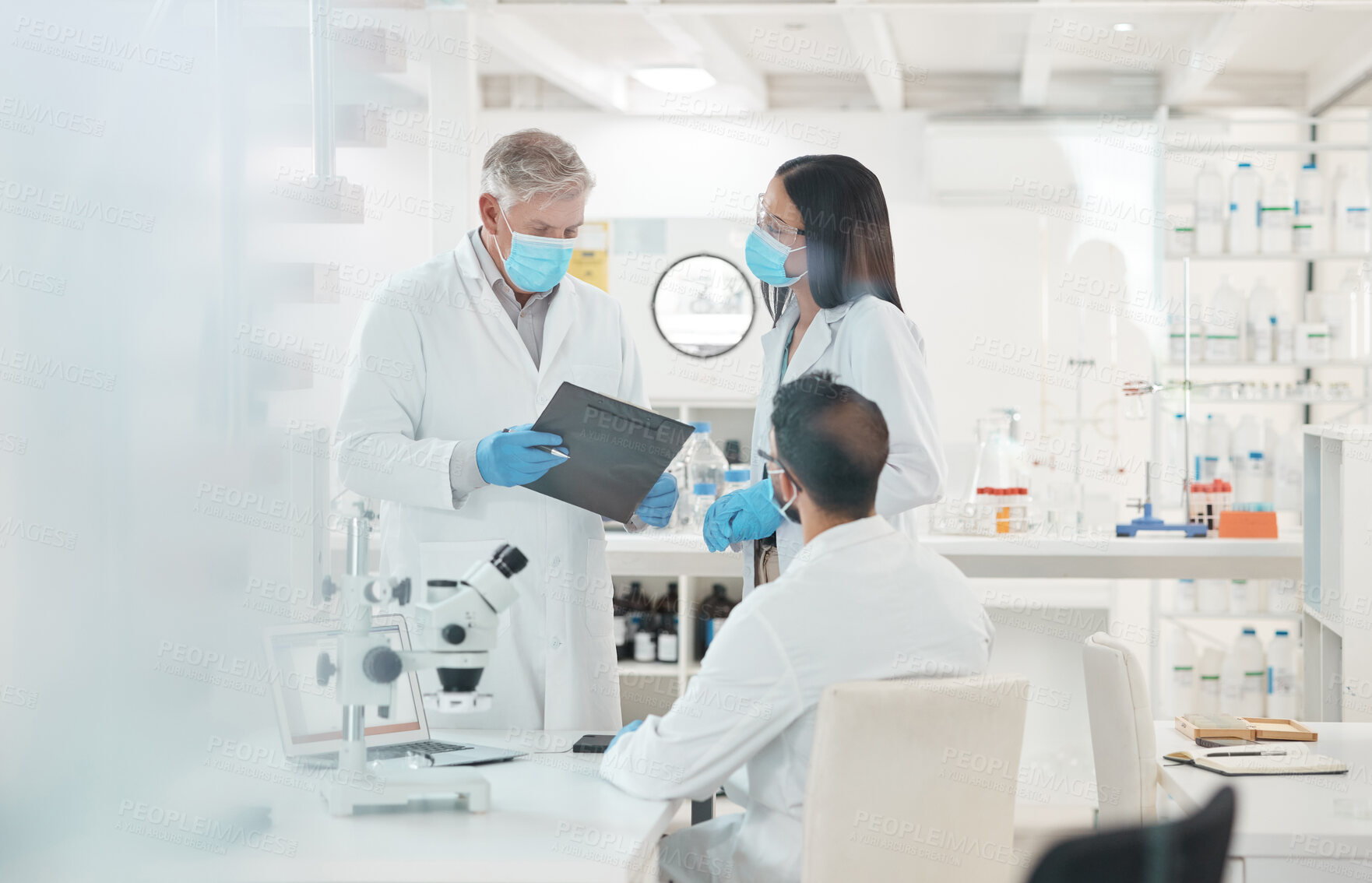 Buy stock photo Shot of a group of scientists working together in a lab