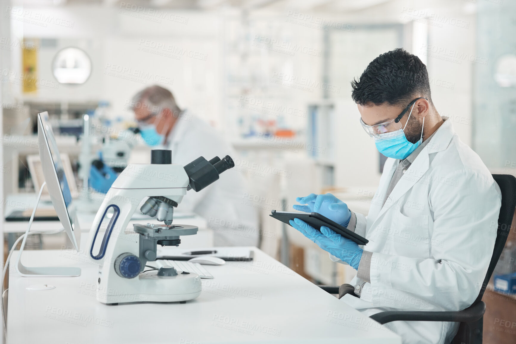 Buy stock photo Shot of a young scientist using a digital tablet while working in a lab