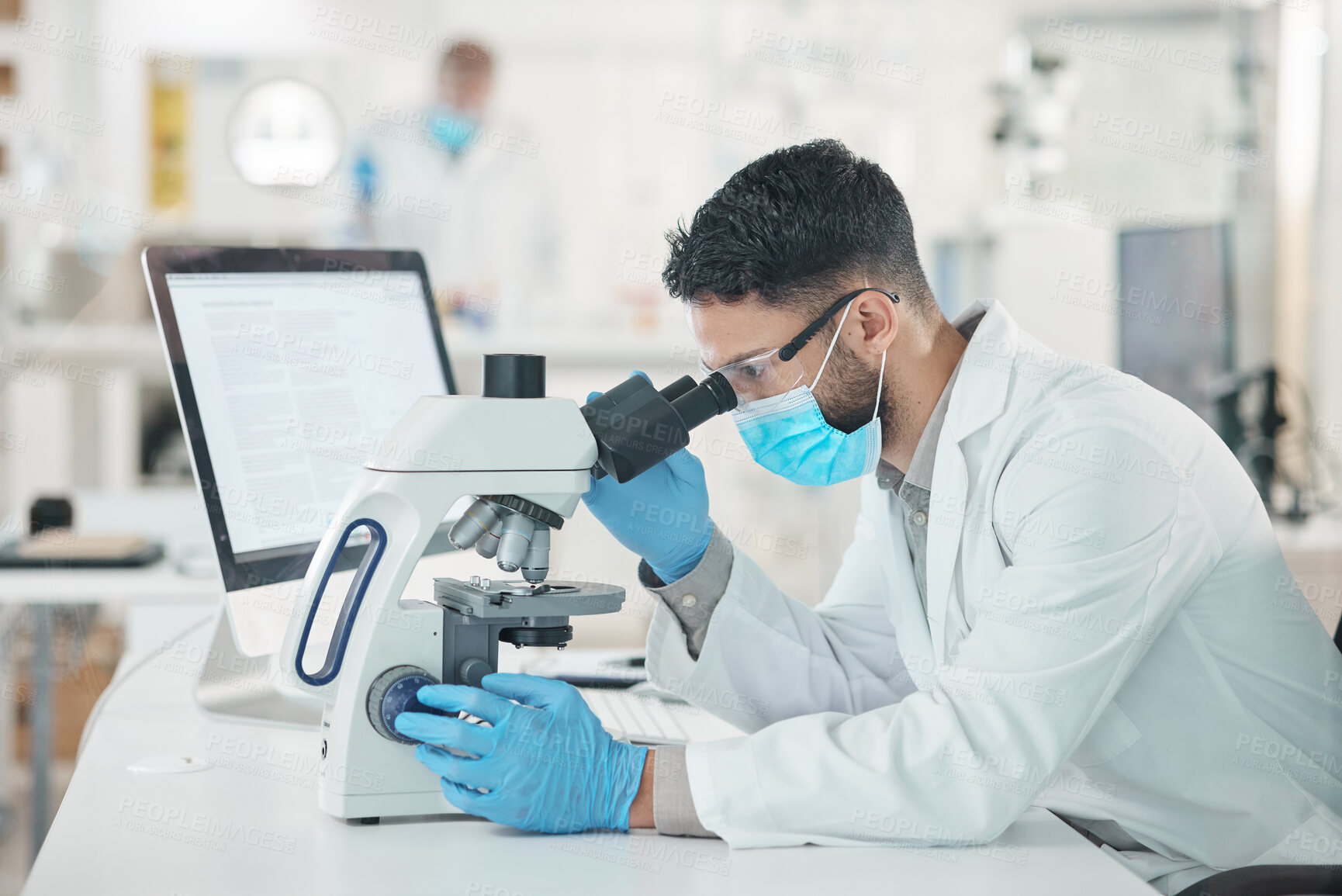 Buy stock photo Shot of a young scientist using a microscope in a lab