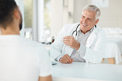 Buy stock photo Shot of a senior doctor sitting with his patient during a consultation in his clinic