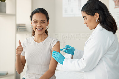 Buy stock photo Shot of an attractive young doctor standing and injecting her patient during a consultation in the clinic