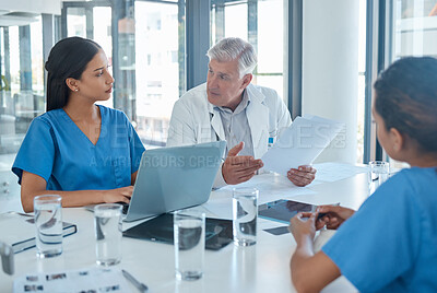 Buy stock photo Shot of a male doctor having a meeting with his staff