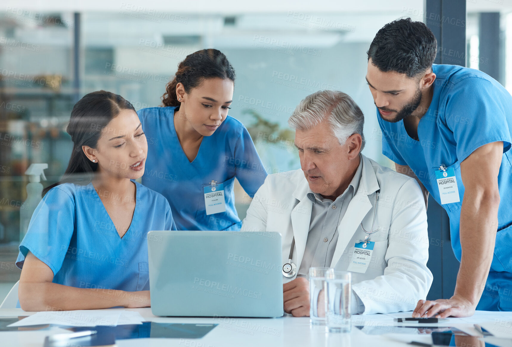 Buy stock photo Shot of a group of nurses having a meeting with their head doctor