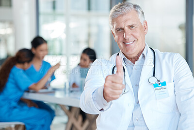 Buy stock photo Shot of a mature male doctor during a meeting giving the thumbs up