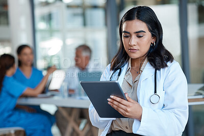 Buy stock photo Shot of a female doctor using a digital tablet during a meeting