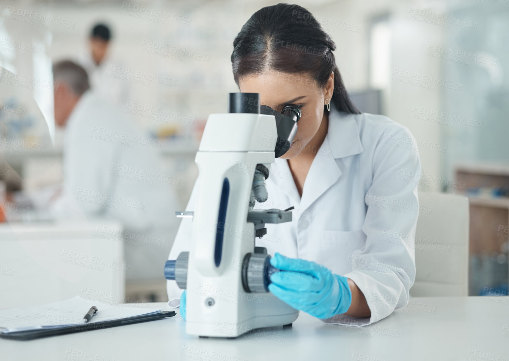 Buy stock photo Scientist, woman and microscope with research and medical analysis in clinic laboratory. Chemistry, testing and hospital doctor with monkeypox vaccine and science work with ppe gear for virus study