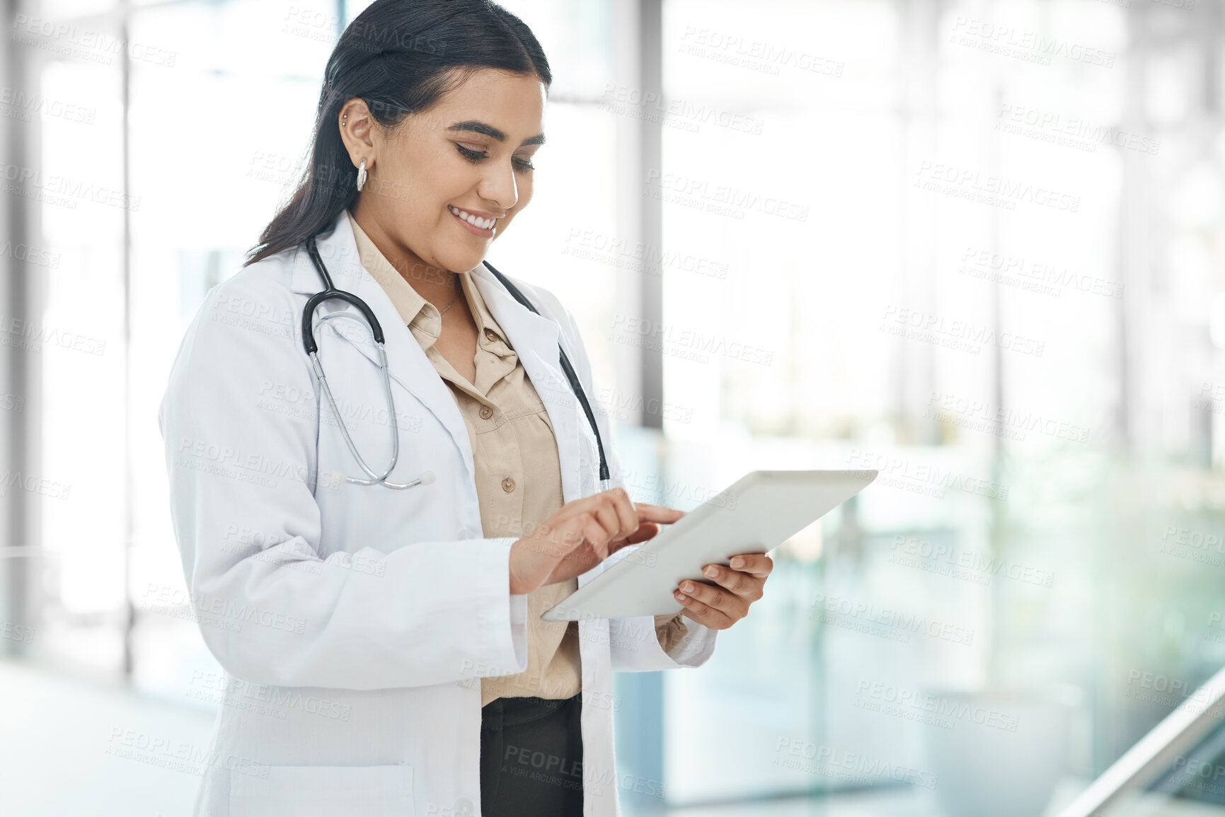 Buy stock photo Shot of a doctor using a tablet in a hospital