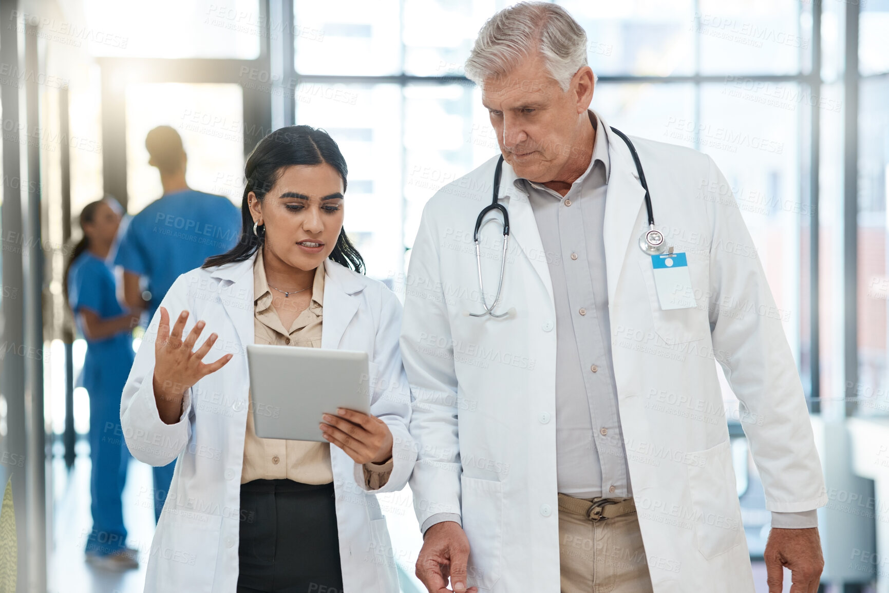 Buy stock photo Shot of a group of medical practitioners having a discussion in a hospital