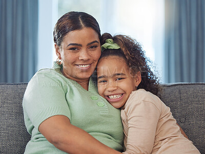 Buy stock photo Shot of an adorable little girl relaxing with her mother on the sofa at home