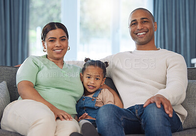 Buy stock photo Shot of an adorable little girl relaxing with her parents on the sofa at home
