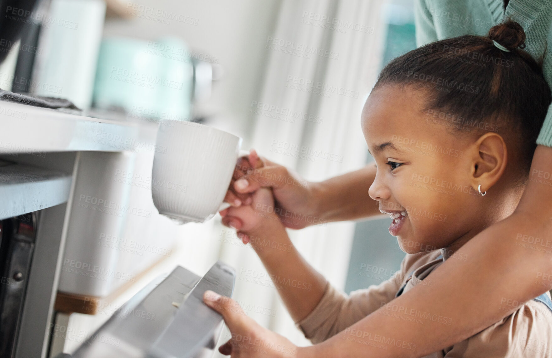 Buy stock photo Shot of a little girl putting a cup into the dishwashing machine at home with her mother