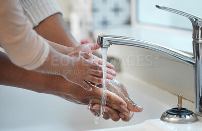 Buy stock photo Shot of an unrecognisable man helping his child wash their hands in the sink at home