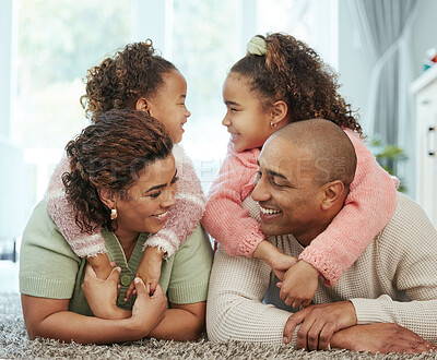 Buy stock photo Shot of a young couple bonding their their two children at home
