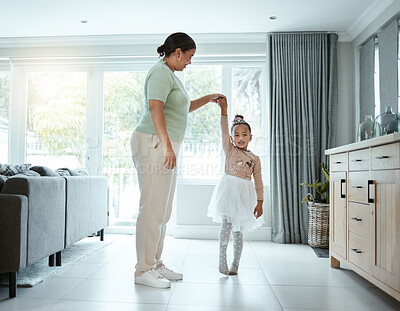 Buy stock photo Shot of a little girl wearing her tutu while dancing with her mother at home