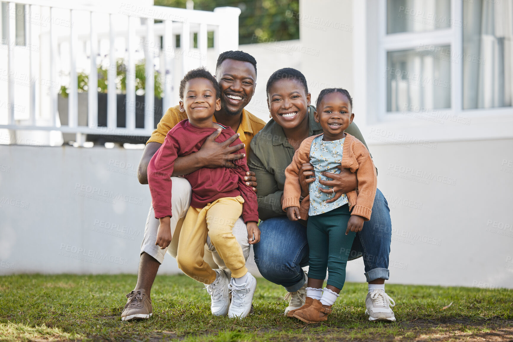 Buy stock photo Shot of a couple standing in front of a house with their two children