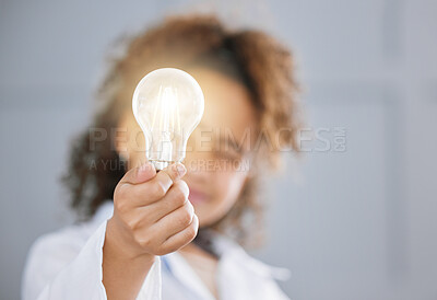 Buy stock photo Cropped shot of an adorable little girl wearing a labcoat and holding out a lightbulb toward the camera