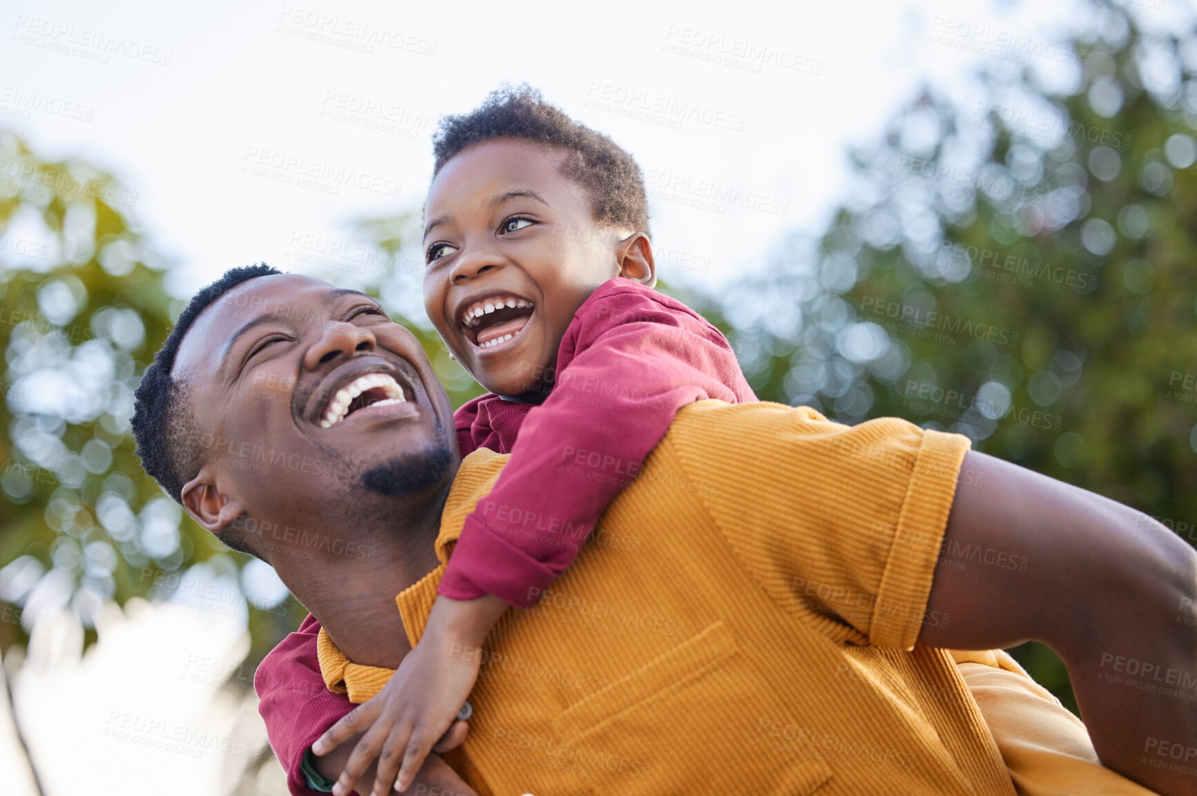 Buy stock photo Happy, playful piggyback and a father child in nature for bonding, game and quality time together. Smile, family and a laughing African dad with a boy kid playing in a garden for love and happiness