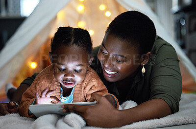 Buy stock photo Black, woman and child relax with tablet at night for streaming story online, watch movie and bonding in tent. Smile, African mother and girl with digital for storytelling , care and love at house