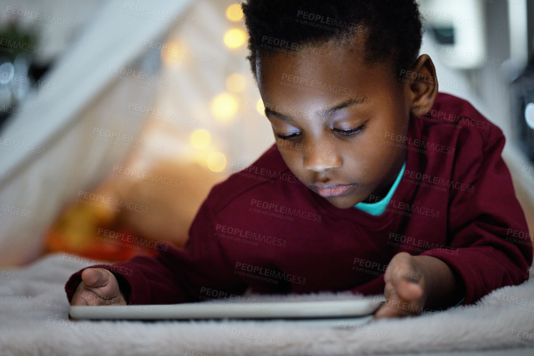 Buy stock photo Black boy and relax with tablet at night for streaming story online, watch movie and website for game in tent. African, child and digital for cartoon subscription, storytelling and ebook at house