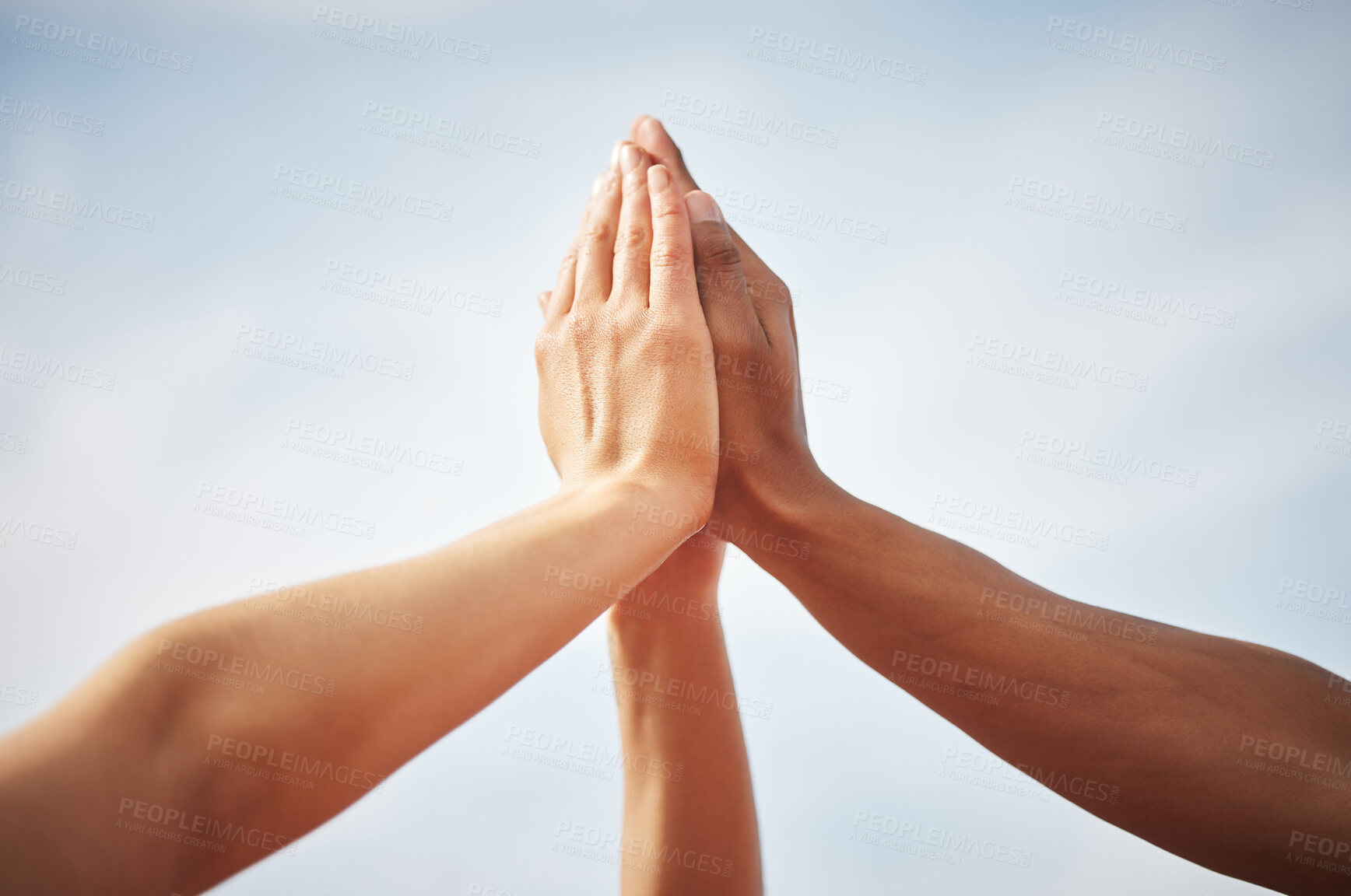 Buy stock photo Cropped shot of three unrecognizable athletes high fiving while standing out on the track