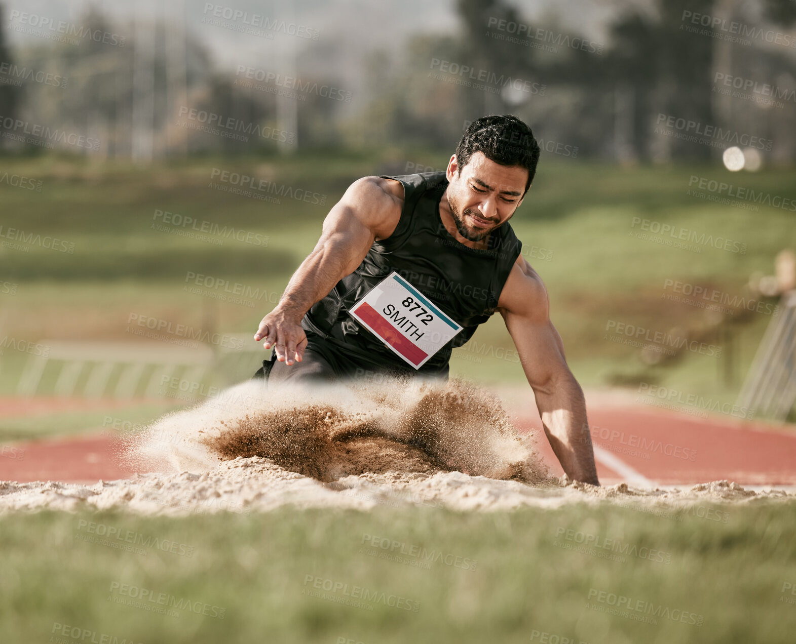 Buy stock photo Full length shot of a handsome young man competing in a long jump event outside