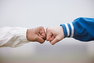 Buy stock photo Cropped shot of two unrecognizable female athletes fist bumping outside