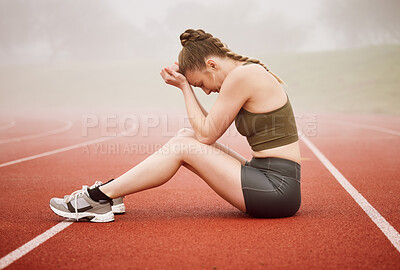 Buy stock photo Full length shot of an attractive young female athlete looking dejected while sitting on the track after a race