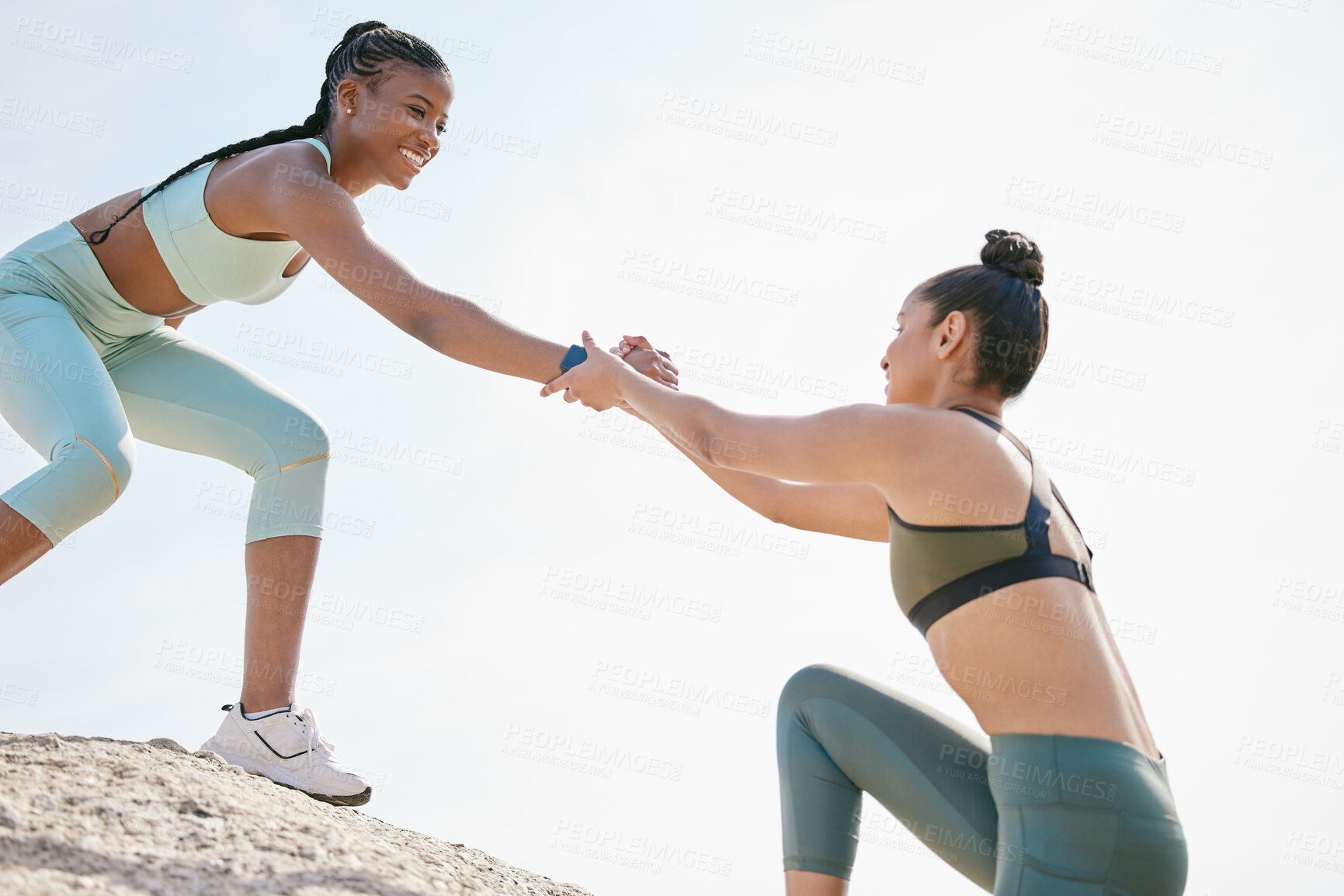 Buy stock photo Help, reach and rock climbing with women on beach together for exercise, fitness or hobby. Assistance, helping hand and training with happy friends outdoor on coast for bonding or wellness in summer