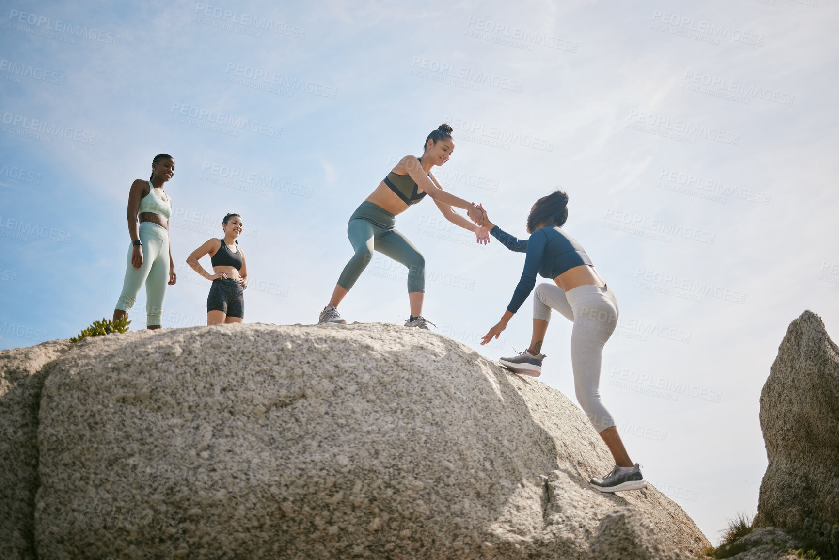 Buy stock photo Help, reach and rock climbing with friends on beach together for exercise, fitness or hobby. Assistance, helping hand and training with happy women outdoor on coast for bonding or wellness in summer