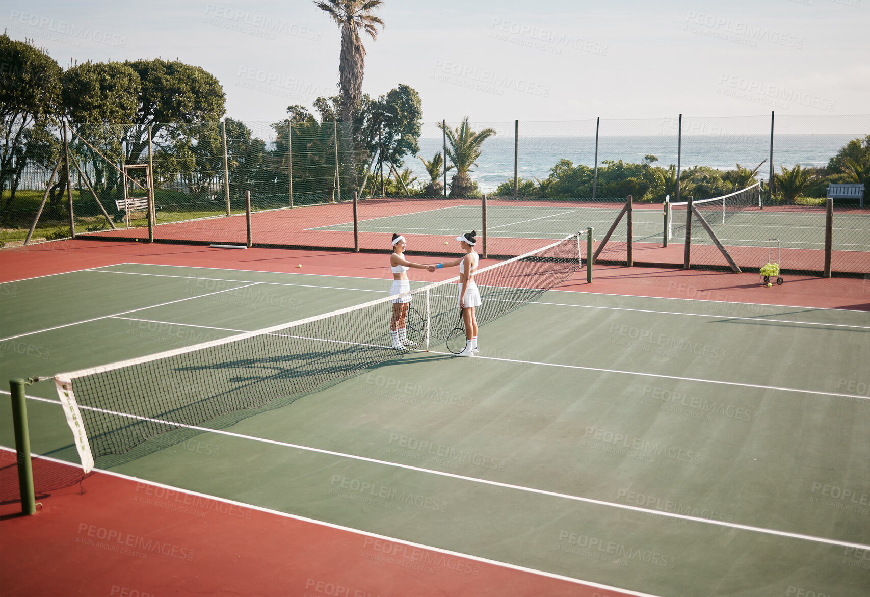 Buy stock photo Full length shot of two young tennis players standing together and shaking hands before practice