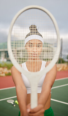 Buy stock photo Shot of a sporty young woman holding a tennis racket in front of her face