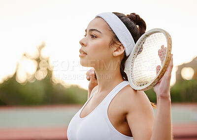 Buy stock photo Shot of a sporty young woman posing with a tennis racket on a court