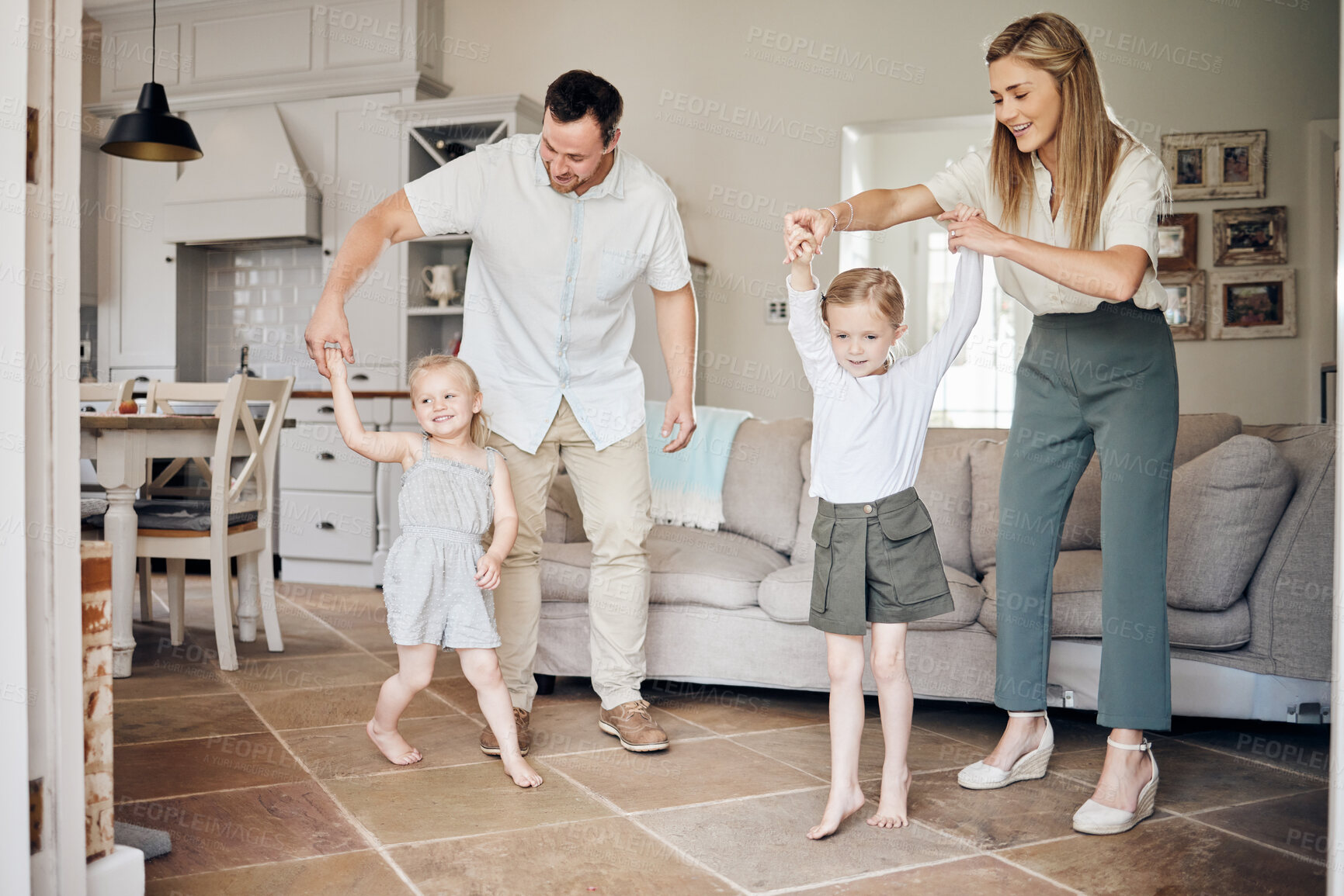 Buy stock photo Parents, children and holding hands with dancing in home for favorite song, teaching move and bonding in lounge. Happy family, people and fun with learning steps with energy, radio music and support