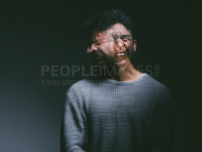 Buy stock photo Studio shot of a young man experiencing mental anguish and screaming against a black background