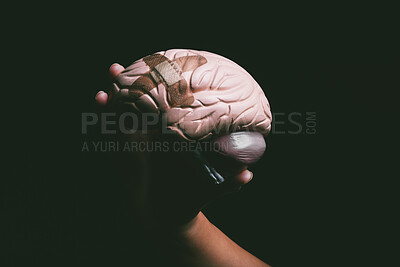 Buy stock photo Shot of an unrecognisable person holding a brain with a band aid on it