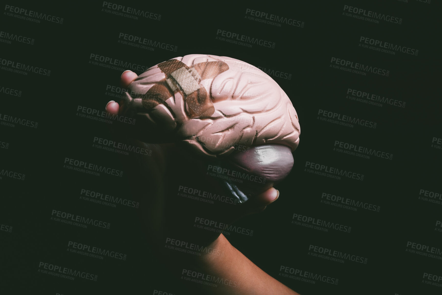 Buy stock photo Bandage, psychology and hands with brain in studio for mental health, depression and anxiety. Thinking, ideas and person with plaster on organ for schizophrenia, mind and medical on black background