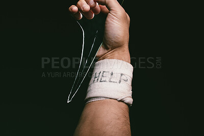 Buy stock photo Shot of an unrecognisable man with bandages wrapped around his wrist showing “help” written on it
