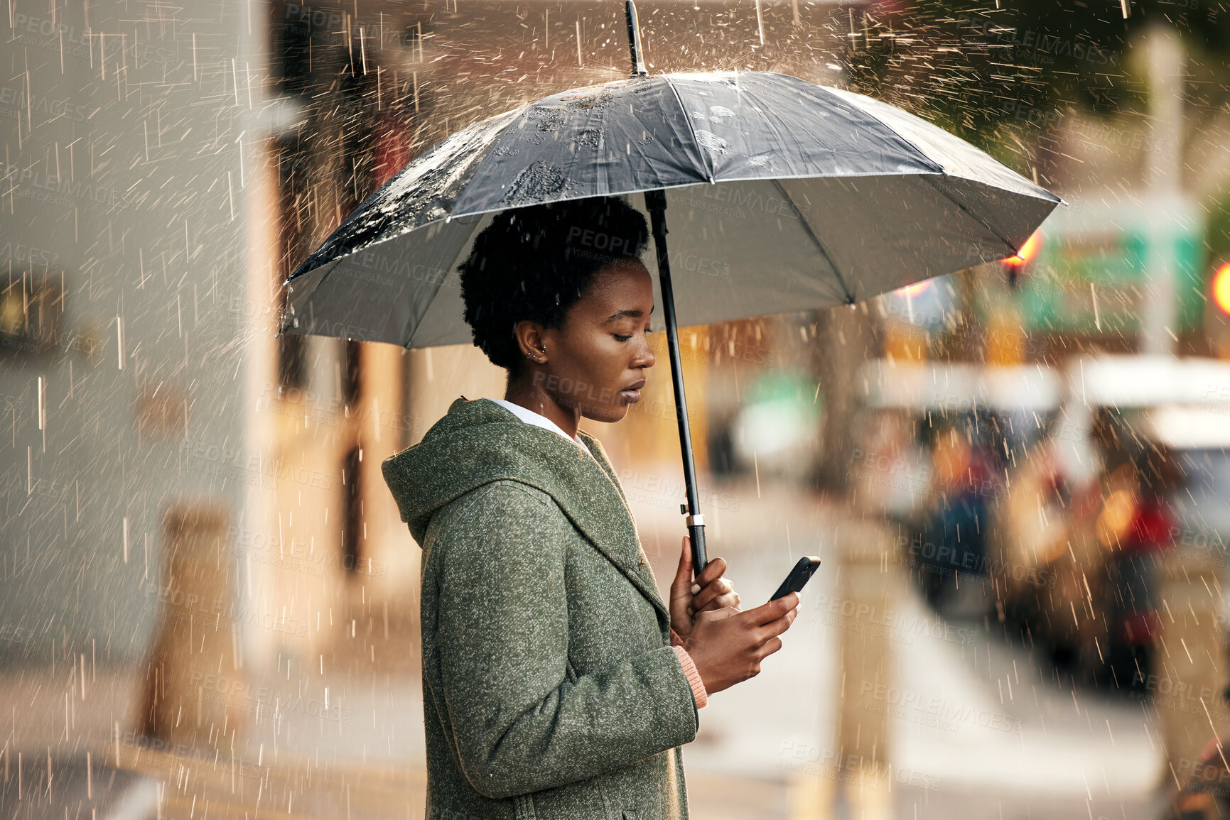 Buy stock photo Black woman, phone and umbrella with rain in city for communication, walk and travel to work. African girl, smartphone and protection from winter weather for internet, email and business update