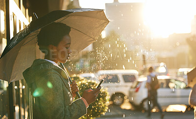Buy stock photo Umbrella, phone and black woman in a city, rain and connection with mobile app, network and chatting. Female person outdoor, weather and girl with a cellphone, contact and communication with cover