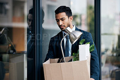 Buy stock photo Depression, economy and a business man with a box walking outdoor in the city after being fired. Financial crisis, unemployment and dismissal with a young male employee looking sad in an urban town