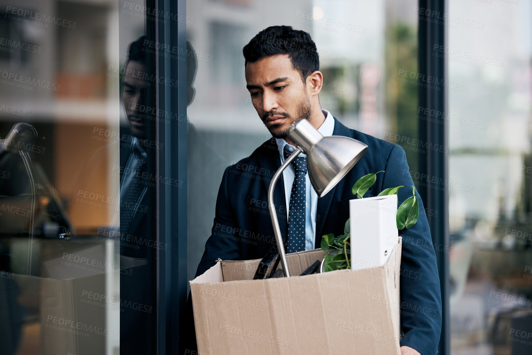 Buy stock photo Depression, economy and a business man with a box walking outdoor in the city after being fired. Financial crisis, unemployment and dismissal with a young male employee looking sad in an urban town