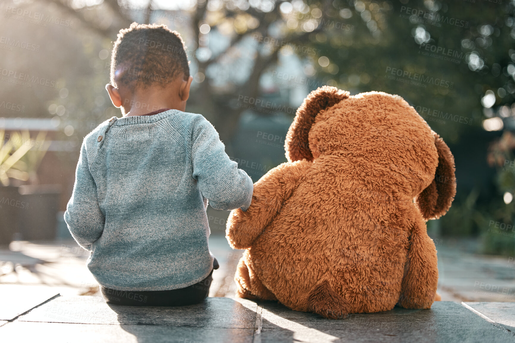 Buy stock photo Child, teddy bear and back in backyard for fantasy, play and enjoyment in sunlight. Young boy, toy and sitting together in garden for games, imagination and development at family home in spring